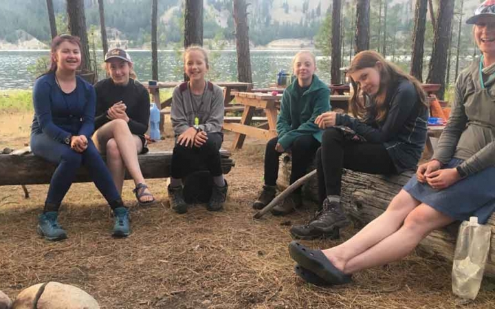 a group of outward bound students rest at a campsite in washington state